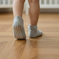 Chaussettes antidérapantes grises avec picots sur un parquet